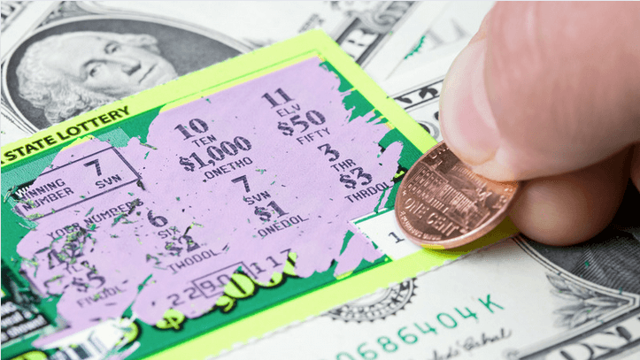 Someone scratching a lottery ticket with a penny